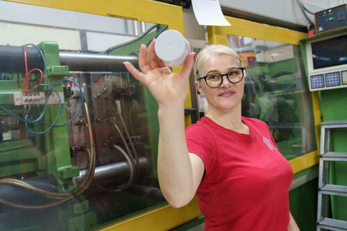 Produktionsmitarbeiterin zeigt Dosenkappe